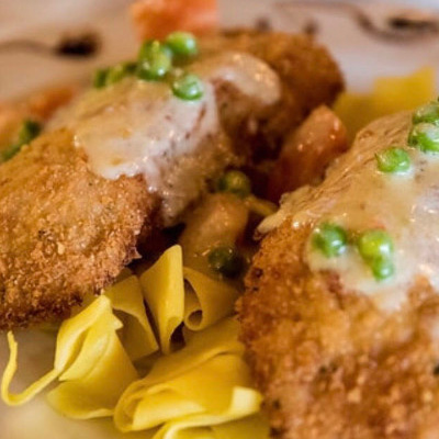Deep Fried Cutlets, served over a pasta with a cream sauce and peas.